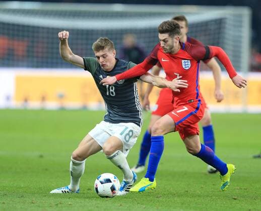 Germany s Toni Kroos tussles with England s Adam Lallana during the International Friendly Länderspiel match at Olympiastadion. Photo credit should read: David Klein Sportimage EDITORIAL USE ONLY. No use with unauthorised audio, video, data, fixture lists, club league logos or live services. Online in-match use limited to 120 images, no video emulation. No use in betting, games or single club league player publications.