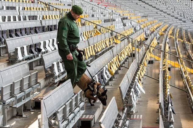 Ein Polizeibeamter kontrolliert mit einem Hund Sitzreihen in der Allianz Arena in München vor dem Freundschaftsspiel der Deutschen Nationalmannschaft gegen Italien.
