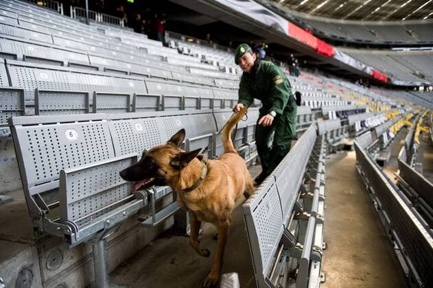 Eine Polizeibeamtin kontrolliert mit einem Hund Sitzreihen in der Allianz Arena in München vor dem Freundschaftsspiel der Deutschen Nationalmannschaft gegen Italien.