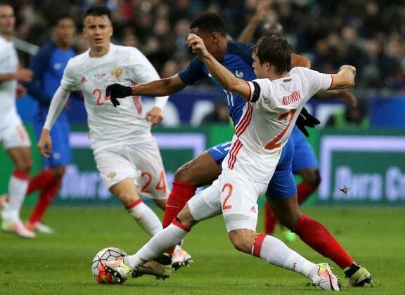 SAINT-DENIS, FRANCE. MARCH 29, 2016. Russia s Alexander Golovin, France s Anthony Martial and Russia s Oleg Kuzmin (L-R) fight for the ball in their friendly football match at the Stade de France. Alexander Demianchuk TASS  TS01DDF8