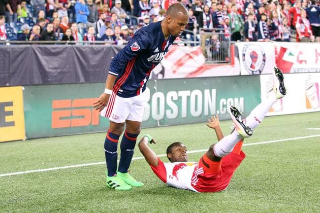 April 1, 2016; Foxborough, MA, USA; New York Red Bulls defender Chris Duvall (25) falls as he battles for the ball with New England Revolution forward Teal Bunbury (10) during the second half of an MLS Fussball Herren USA game between the New England Revolution and New York Red Bulls at Gillette Stadium. New England won 1-0. MLS 2016: Red Bulls vs Revolution APR 01 - ZUMAc04_