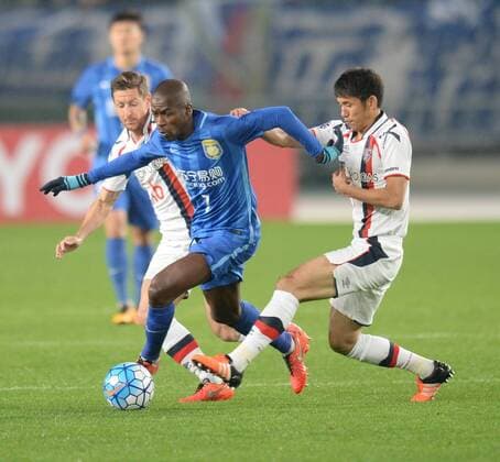 Ramires Santos of China s Jiangsu Suning, center, challenges Takuji Yonemoto, right, and Nathan Burns, left, of Japans FC Tokyo in their Group E match during the AFC Champions League 2016 in Nanjing city, east China s Jiangsu province, 6 April 2016. Jiangsu Suning vs FC Tokyo at AFC Champions League  20160406_65159