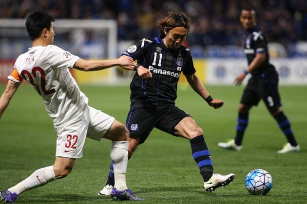 OSAKA, JAPAN - APRIL 06: (CHINA OUT) Sun Xiang 32 of Shanghai SIPG and Shu Kurata 11 of Gamba Osaka compete for the ball during the AFC Champions League Group G match between Gamba Osaka and Shanghai SIPG at Suita City Stadium on April 6, 2016 in Osaka, Japan.  CFP482304730 