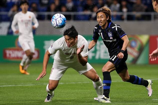 OSAKA, JAPAN - APRIL 06: (CHINA OUT) Cai Huikang 6 of Shanghai SIPG and Shu Kurata 11 of Gamba Osaka compete for the ball during the AFC Champions League Group G match between Gamba Osaka and Shanghai SIPG at Suita City Stadium on April 6, 2016 in Osaka, Japan.  CFP482304735 
