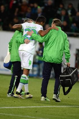 v.li.: Zwei Betreuer schaffen Luiz GUSTAVO (VfL Wolfsburg, 22) vom Feld, mit Schmerzen nach einem Foul, racked with pain, Fussball, UEFA Champions League, VfL Wolfsburg - Real Madrid, xslx