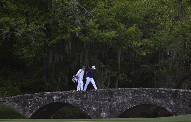 Shane Lowry of Ireland and his caddie Dermot Byrne walk on Nelson Bridge in the first round of the 2016 Masters Tournament at Augusta National in Augusta, Georgia on April 7, 2016.  AUG20160407307 KEVINxDIETSCH
