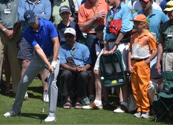 A fan dressed as Rickie Fowler watches Jordan Spieth chip to the 6th green in the second round of the 2016 Masters Tournament at Augusta National in Augusta, Georgia on April 8, 2016.  MAS20160408152A KEVINxDIETSCH