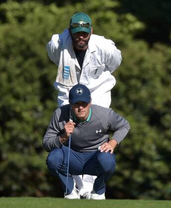Caddie Michael Greller and Jordan Spieth line up a putt on the 11th green in the third round of the 2016 Masters Tournament at Augusta National in Augusta, Georgia on April 9, 2016.  MAS20160409134 KEVINxDIETSCH