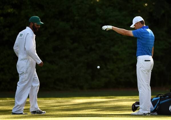 Caddie Michael Greller watches Jordan Spieth take a drop after he hits his tee shot into Rae s Creek on the 12th hole par 3 in the final round of the 2016 Masters Tournament at Augusta National in Augusta, Georgia on April 10, 2016.  MAS20160410135 KEVINxDIETSCH