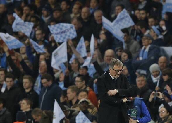 A dejected looking Laurent Blanc manager of Paris Saint Germain as Manchester City fans celebrate during the UEFA Champions League match at The Etihad Stadium. Photo credit should read: Simon Bellis Sportimage EDITORIAL USE ONLY. No use with unauthorised audio, video, data, fixture lists, club league logos or live services. Online in-match use limited to 120 images, no video emulation. No use in betting, games or single club league player publications.