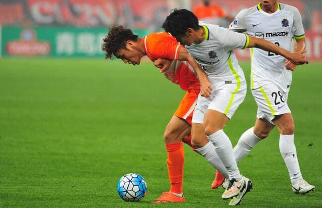 Wu Xinghan of China s Shandong Luneng, left, challenges a player of Japan s Sanfrecce Hiroshima in their Group F match during the 2016 AFC Champions League in Jinan city, east China s Shandong province, 20 April 2016. Shandong Luneng defeated Sanfrecce Hiroshima 1-0. Shandong Luneng beats Sanfrecce Hiroshima at AFC Champions League  20160420_12233