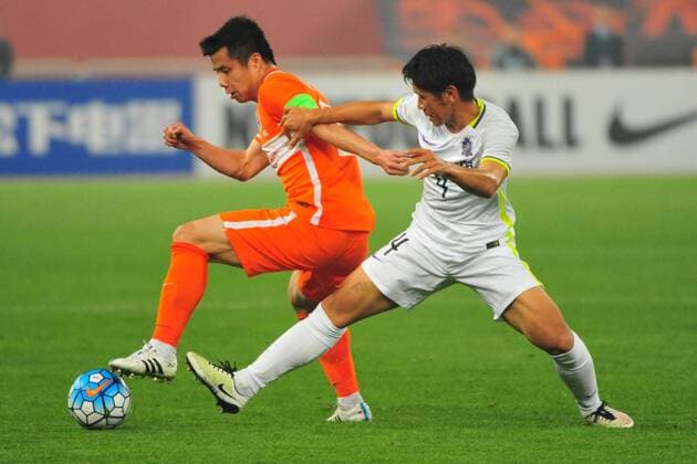 Hao Junmin of China s Shandong Luneng, left, challenges Hiroki Mizumoto of Japan s Sanfrecce Hiroshima in their Group F match during the 2016 AFC Champions League in Jinan city, east China s Shandong province, 20 April 2016. Shandong Luneng defeated Sanfrecce Hiroshima 1-0. Shandong Luneng beats Sanfrecce Hiroshima at AFC Champions League  20160420_51009