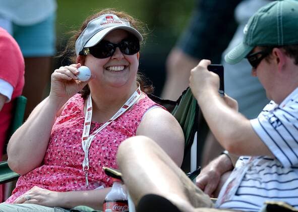 May 7, 2016 - Charlotte, NC, USA - Katie Winfrey of Winston-Salem, N.C., smiles as her husband, Lee Winfrey, takes a photo of her with the ball golfer James Hahn hit that landed in her chair arm in the third round of the Wells Fargo Championship at Quail Hollow Club in Charlotte, N.C., on Saturday, May 7, 2016. The ball landed between her arm and the beverage holder on her chair. Wells Fargo Championship, third round - ZUMAm67_