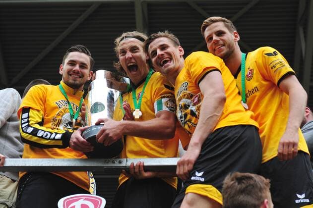 Fußball, Dynamo Dresden feiert Aufstieg in 2. Bundesliga v.l.: Pascal Testroet, Michael Hefele, Stefan Kutschke und Justin Eilers (alle Dresden) mit Pokal bei den Fans im K-Block, Dynamo Dresden ist Meister der 3. Liga, Drittligameister, 3. Liga-Meister, Siegerehrung mit Pokal, SG Dynamo Dresden gegen SG Sonnenhof Großaspach, Fußball, Fussball, 3. Liga, Saison 2015 2016, DDV-Stadion Dresden, 14.05.2016,