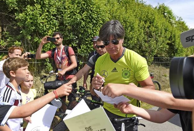 26.05.2016, Fussball DFB-Nationalmannschaft, Vorbereitung zur EM-2016, Trainingslager in Ascona im Tessin (Schweiz) im Stadio Comunale in Ascona. Bundestrainer Joachim Löw (Deutschland) fährt nach dem Training mit dem Mountain-Bike zum Hotel zurück, Fans die am Rande stehen halten ihn an und bekommen Autogramme. 