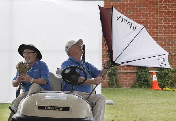 Golf, ProAm Turnier in Fort Worth May 26, 2016 - Fort Worth, TX, USA - Marshall J.R. Rambo, right, with Drew Martin, left, wrestles with his umbrella turned inside-out during round one of the Dean & DeLuca Invitational Thursday, May 26, 2016, in Fort Worth, Texas. With play suspended at 8:29am, players, fans and marshalls headed for cover. Dean & DeLuca Invitational - ZUMAm67_