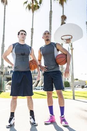 Two young men standing on outdoor basketball court model released Symbolfoto  LEF000094