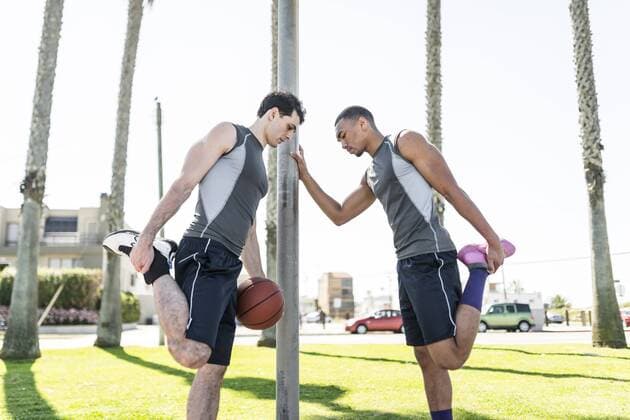 Two basketball players stretching outdoors model released Symbolfoto  LEF000117