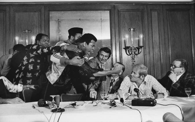 Boxing : Ali Dunn press conference PK Pressekonferenz Ali is held back by Bundini Brown. Muhammad Ali v Richard Dunn. Pre : World Heavyweight Championship Title fight. Munich , Germany. 23 05 1976 
