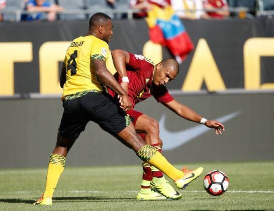 Jamaica defender Wes Morgan (L) kicks the ball away from Venezuela forward Jose Salomon Rondon during the second half of a 2016 Copa America Centenario Group C match at Soldier Field in Chicago on June 5, 2016. Venezuela defeated Jamaica 1-0.  CHI2016060529 BRIANxKERSEY