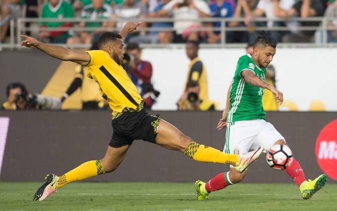 Mexico s Jesus Manuel Corona (R) passes the ball as Jamaica s Giles Barnes tries to stop him during the Copa America Centenario tournament Group C football match in Pasadena, California, the United States, on June 9, 2016. ) (SP)U.S.-PASADENA-COPA AMERICA-GROUP C-MEX VS JAM YangxLei 