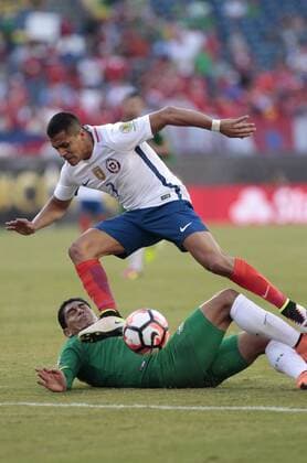 Chile forward Alex Sanchez (7) leaps over an attempted slide tackily by Bolivia defender Edward Zenteno (22) in the first half of the Copa America Centenario Group D match at Gillette Stadium in Foxboro, Massachusetts on on June 10, 2016.  BOS2016061007 MATTHEWxHEALEY