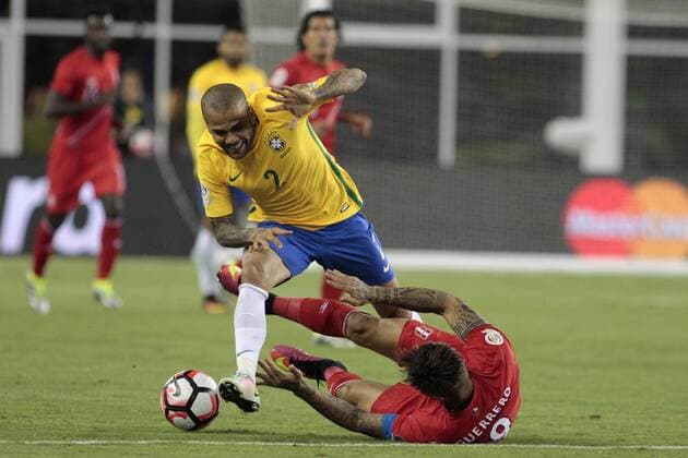 Brazil defenseman Dani Alves (2) trips over Peru forward Jose Guerrero (9) in the first half of the 2016 Copa America Centenario Group B match at Gillette Stadium in Foxborough, Massachusetts on June 12, 2016. Peru defeated Brazil 1-0.  BOS2016061210 MATTHEWxHEALEY