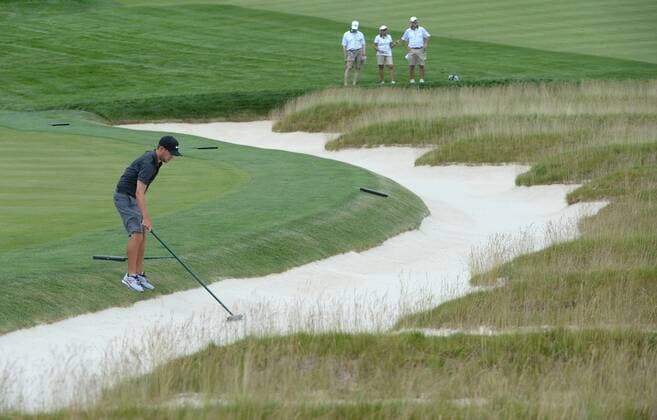 Kevin Tway s caddie Bob Tway fixes the sand in the Church Pews bunkers during a practice round prior to the start of the 2016 U.S. Open at Oakmont Country Club in Oakmont, Pennsylvania on June 15, 2016.  PIT20160615403 PATxBENIC