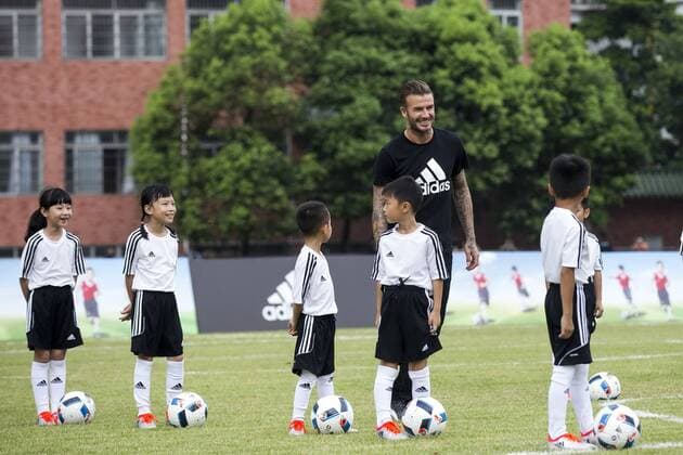 Bilder des Tages - SPORT David Beckham trainiert mit Kindern in China English football star David Beckham instructs young Chinese kids to play football during a football campaign by Adidas at Zhixin High School in Guangzhou city, south China s Guangdong province, 28 June 2016. David Beckham coaches young kids to play football in south China  20160628_51482
