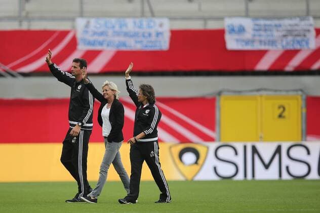 Ehrenrunde v.l. Michael Fuchs, Torwarttrainer (GER), Headcoach Silvia Neid (GER), Assistant Coach Ulrike Ballweg (GER). Im Hintergrund haengen Plakate fuer Silvia neid