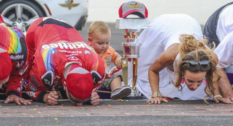 Bilder des Tages - SPORT Kyle Busch and his wife Samantha kiss the bricks while his son Brexton takes care of the trophy after winning the 23rd Brickyard 400 at the Indianapolis Motor Speedway on July 24, 2016 in Indianapolis, Indiana.  IND2016072442 EdxLocke