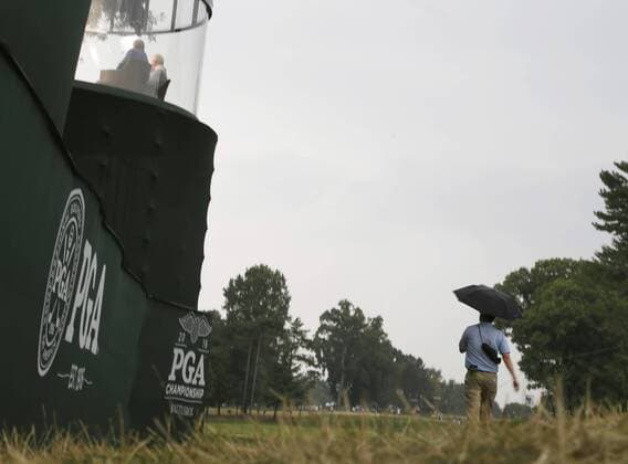 A fan walks with an umbrella as rain approaches in the 3rd round at the PGA Golf Herren Championship at Baltusrol Golf Club in Springfield, New Jersey on July 30, 2016.  PGA20160730101 JOHNxANGELILLO