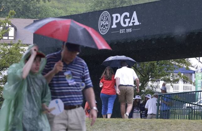 Patrons walk the golf course carrying umbrellas in the rain before play is suspended due to rain in the 3rd round at the PGA Golf Herren Championship at Baltusrol Golf Club in Springfield, New Jersey on July 30, 2016.  PGA20160730117 JOHNxANGELILLO