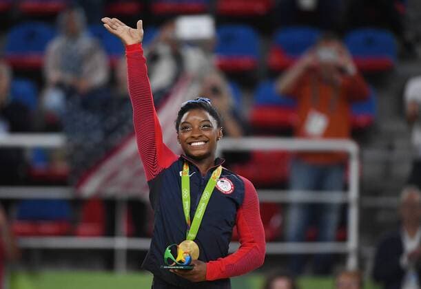 Simone Biles waves holding her gold medal after competeing at the Women s Individual all around in artistic gymnastics at HSBC Arena (Arena Ol?mpica do Rio) at the 2016 Rio Summer Olympics in Rio de Janeiro, Brazil, on August 11, 2016. Simone Biles won an Olympic gold in the women s all-around competition and teammate Aly Raisman, won a silver medal in the event.  OLY20160808112061 TERRYxSCHMITT