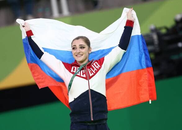RIO DE JANEIRO, BRAZIL - AUGUST 14, 2016: Aliya Mustafina of Russia waves her national flag as she wins the artistic gymnastics women s uneven bars event at the 2016 Summer Olympic Games Olympische Spiele Olympia OS at the Rio Olympic Arena. Stanislav Krasilnikov TASS  TS02D153