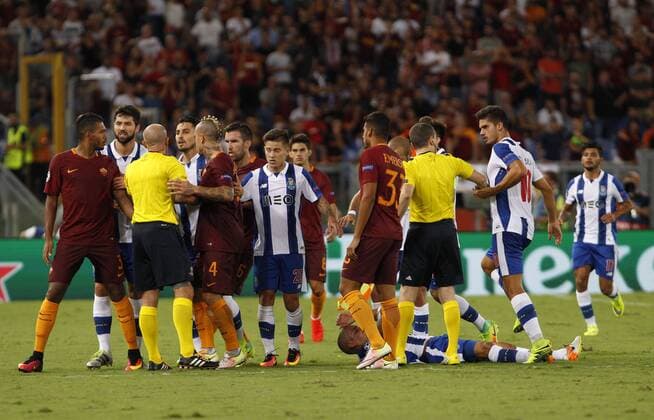 Italy: Soccer Champions League: Porto defeats Roma Roma and FC Porto s players argue with referee Szymon Marciniak during their Champions League play-offs second leg soccer match at the Olympic stadium. Porto won 3-0 to join the tournament group stage.  RiccardoxDexLucax xPacificxPress