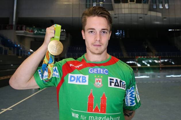 Handball, 1. BL, SC Magdeburg Porträttermin Michael Damgaard (SC Magdeburg) mit seiner olympischen Goldmedaille von Rio - Handball Bundesliga Saison 2016-2017 Offizeller Fototermin SC Magdeburg in der GETEC Arena in Magdeburg - Einzelbild,Portrait,Deutschland, Handball, Mann, Maenner,25.08.2016