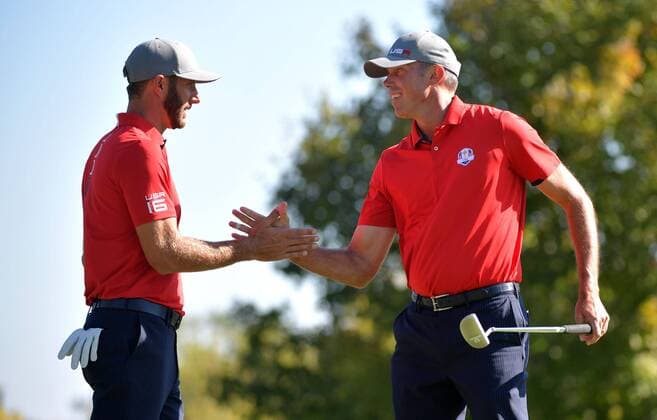 USA team member Dustin Johnson (L) celebrates with teammate Matt Kuchar after the two won their match during the first day of the 2016 Ryder Cup at Hazeltine National Golf Club in Chaska, Minnesota on September 30, 2016.  MIN20160930302 KEVINxDIETSCH