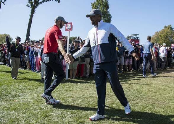 USA team vice-captain Tiger Woods (R) congratulates Dustin Johnson after he made a putt to win the 13th hole during day 1 of the 2016 Ryder Cup at Hazeltine National Golf Club in Chaska, Minnesota on September 30, 2016.  MIN20160930306 KEVINxDIETSCH