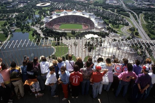 Fans des FC Bayern München auf dem Olympiaturm mit Blick auf das ausverkaufte Münchner Olympiastadion
