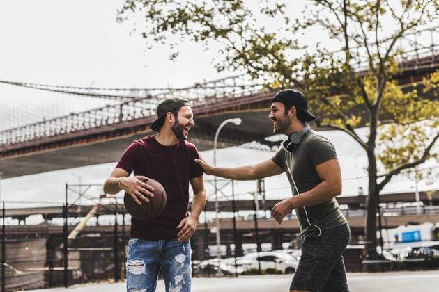 Two young men with basketball having fun on an outdoor court model released Symbolfoto  UUF09148