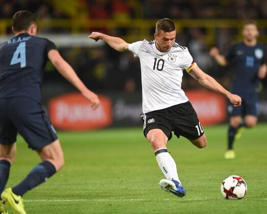 Fußball, Deutschland - England Fußball-Länderspiel: Deutschland - England 22.03.2017 in Dortmund. Lukas Podolski (Deut.) holt zum Schuß aus. Li: Michael Keane (ENG 4). HM