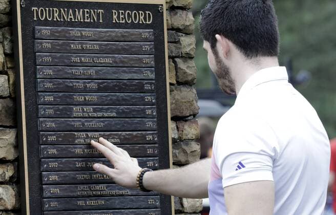 A fan touches Tiger Wood s name on a tournament record plaque during a practice round at the 2017 Masters Tournament at Augusta National Golf Club in Augusta, Georgia on April 3, 2017. Play was suspended at 2:30 PM for the day based on a new weather forecast.  AUG20170403102 JOHNxANGELILLO