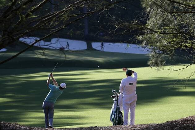 Caddie Mark Fulchera watches Justin Rose of Great Britain hit to the 13th green in a practice round on Tuesday at the 2017 Masters Tournament at Augusta National Golf Club in Augusta, Georgia on April 4, 2017.  AUG20170404149 JOHNxANGELILLO