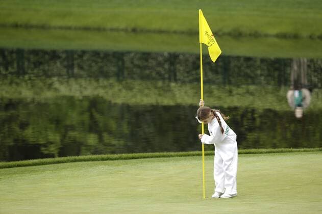 Mya Immelman, daughter of Trevor Immelman, puts in the flag stick on the 9th hole after the traditional par 3 contest was canceled due to approaching rain and thunderstorms on Wednesday at the 2017 Masters Tournament at Augusta National Golf Club in Augusta, Georgia on April 5, 2017.  AUG20170405608 JOHNxANGELILLO