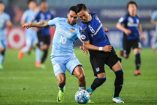 Brazilian football player Alex Teixeira of China s Jiangsu Suning, left, challenges Yosuke Ideguchi of Japan s Gamba Osaka in their Group H match during the AFC Champions League 2017 in Nanjing city, east China s Jiangsu province, 11 April 2017. Jiangsu Suning defeated Gamba Osaka 3-0. Jiangsu Suning defeats Gamba Osaka at AFC Champions League group match  20170411_06664