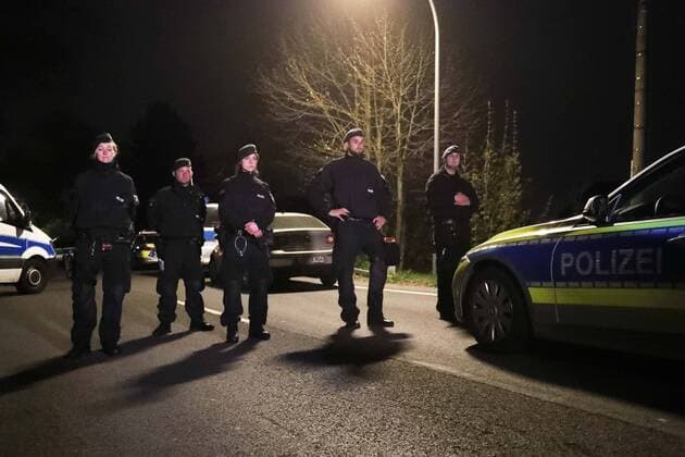 (170411) -- DORTMUND (GERMANY), April 11, 2017 -- Police officers stand guard near the site where German soccer team Dortmund s bus was damaged by explosions in Dormund, Germany, on April 11, 2017. German soccer team Dortmund said Tuesday that its Champions League match against Monaco was canceled and one player injured after explosions hit team bus. Three explosions hit Dortmund team s bus in the district of Hoechsten of the western German city of Dortmund. ) GERMANY-DORTMUND-SOCCER TEAM-BUS-EXPLOSION UlrichxHufnagel 