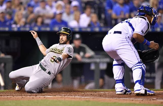 April 12, 2017 - Kansas City, MO, USA - The Oakland Athletics Trevor Plouffe scores behind Kansas City Royals catcher Salvador Perez on a double by Rajai Davis in the third inning at Kauffman Stadium in Kansas City, Mo., on Wednesday, April 12, 2017. Oakland at Kansas City - ZUMAm67_ 20170412_zaf_m67_029 Copyright: xJohnxSleezerx