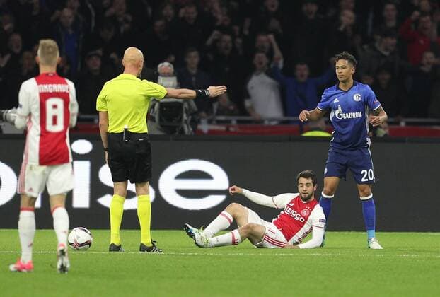 13.04.2017, Fussball, UEFA Europa League, Saison 2016 2017, Viertelfinale, Ajax Amsterdam - FC Schalke 04, Schiedsrichter Sergei Karasev zeigt auf den Elfmeterpunkt, Amin Younes (Ajax Amsterdam) am Boden, rechts Thilo Kehrer (Schalke 04)