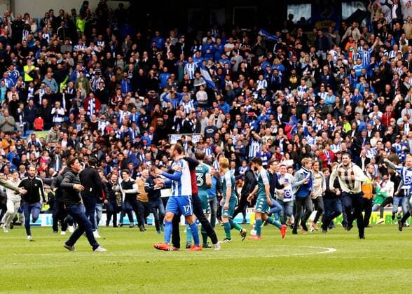 April 17th 2017, Brighton, Sussex, England; Skybet Championship football, Brighton and Hove Albion versus Wigan Athletic; Referee James Linington blows the final whistle, and runs to the tunnel, as Glenn Murray of Brighton is congratulated by fans as they run onto the pitch xMarkxKertonx  ActionPlus11869245